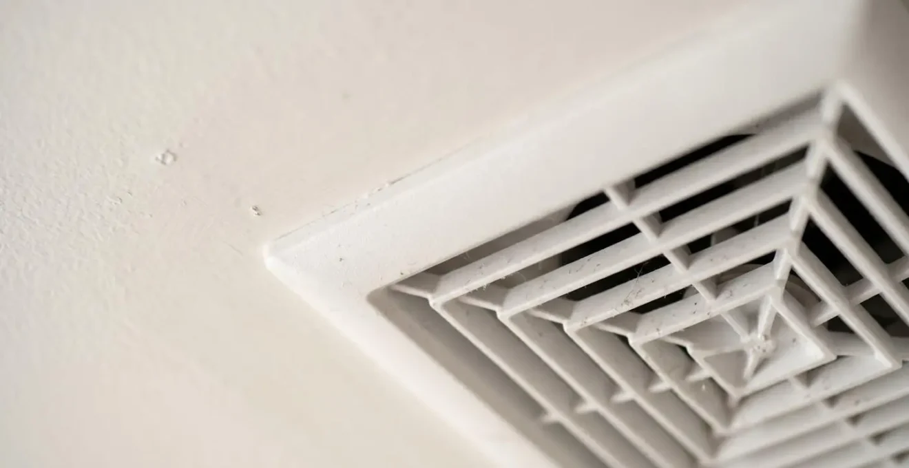 Gros plan détaillé sur un système de ventilation VMC moderne installé dans un logement rénové avec grilles d'aération